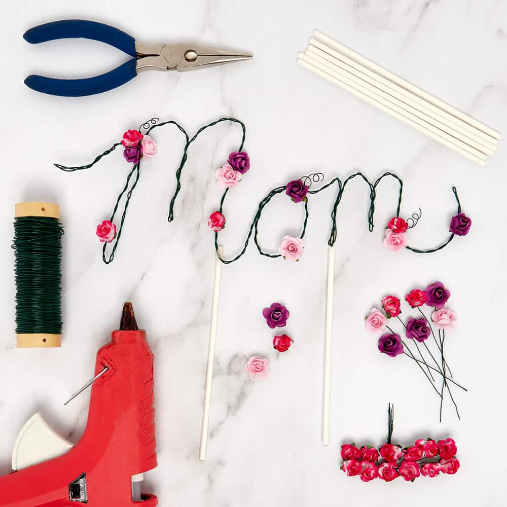 Etiqueta de alambre hecha a mano para el Día de la Madre rodeada de artículos de mercado hechos a mano